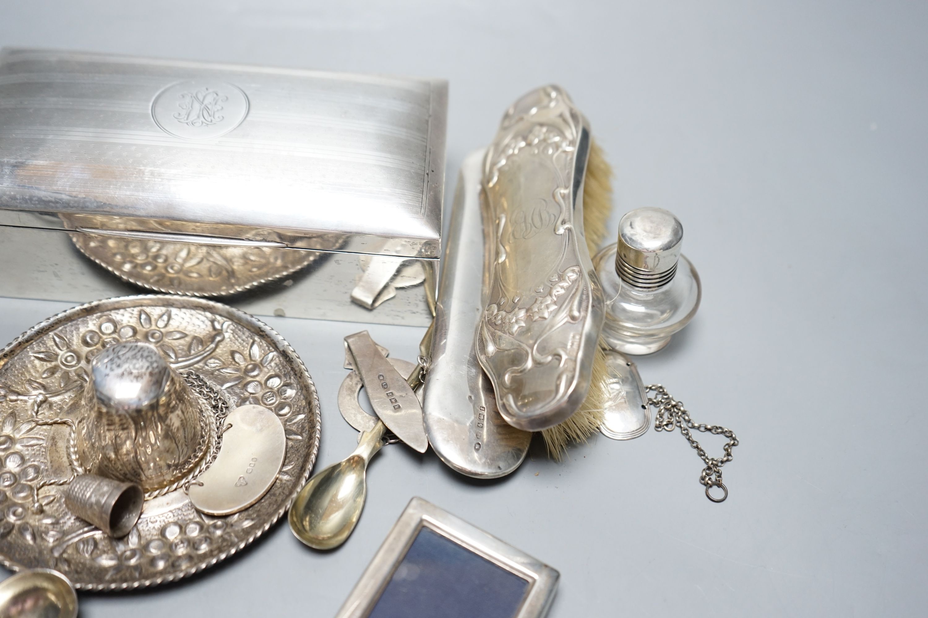 Assorted small silver including a cigarette box, pair of German 800 pepperettes, wine labels, spectacles case etc.